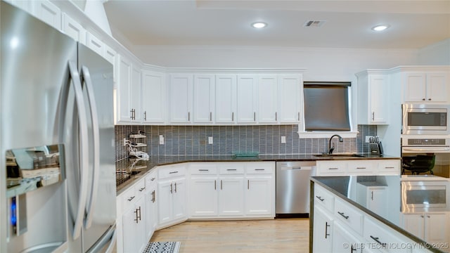 kitchen featuring appliances with stainless steel finishes, light hardwood / wood-style floors, sink, and white cabinets