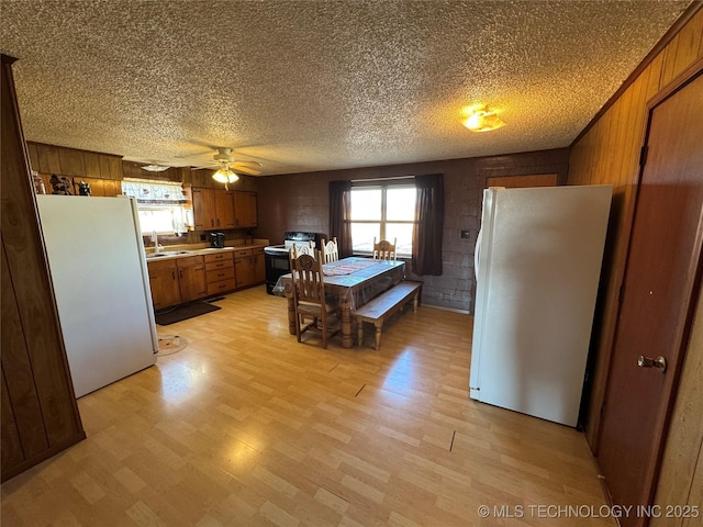 kitchen featuring sink, stainless steel refrigerator, black electric range, a textured ceiling, and white fridge