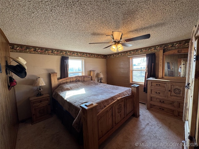 carpeted bedroom featuring multiple windows, ceiling fan, and a textured ceiling