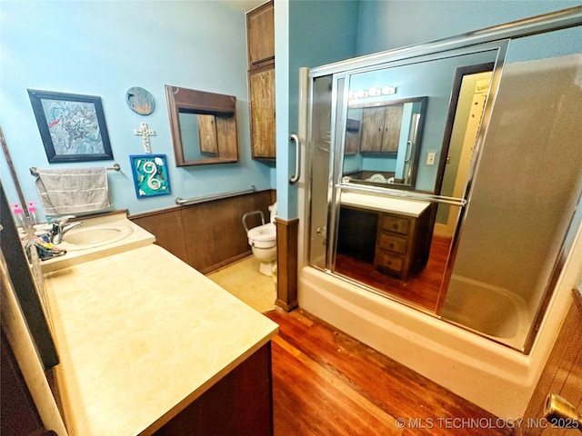 full bathroom featuring vanity, hardwood / wood-style floors, shower / bath combination with glass door, and toilet