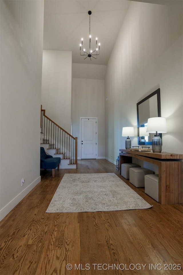 entrance foyer with an inviting chandelier, hardwood / wood-style flooring, and a high ceiling