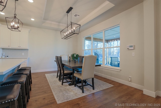 dining room with a raised ceiling and hardwood / wood-style floors