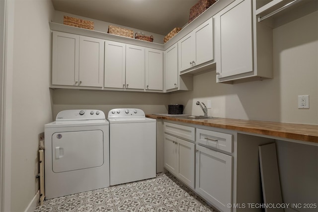 laundry room with cabinets, sink, washing machine and dryer, and light tile patterned floors