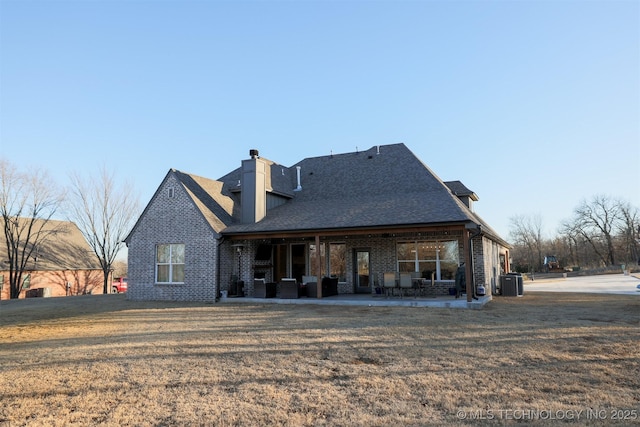 rear view of property featuring a yard, central AC, and a patio