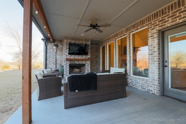 view of patio featuring an outdoor living space with a fireplace and ceiling fan