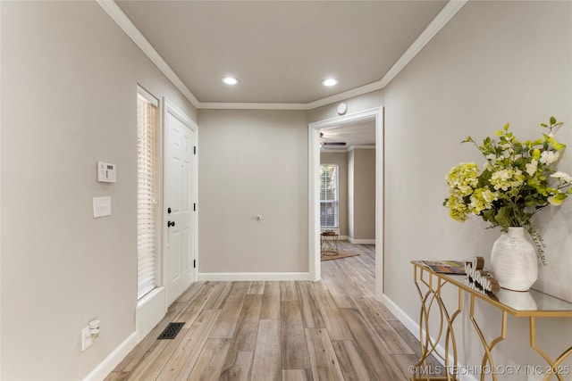 entryway featuring ornamental molding and light hardwood / wood-style flooring