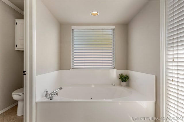 bathroom featuring tile patterned flooring, a bathing tub, and toilet