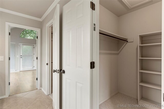 walk in closet with light tile patterned floors