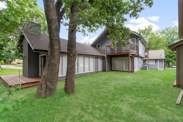 back of house with central AC, a deck, and a lawn