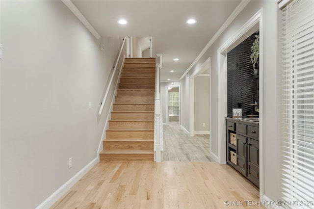 staircase with crown molding and hardwood / wood-style flooring