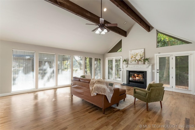 living room with ceiling fan, beam ceiling, high vaulted ceiling, and light wood-type flooring