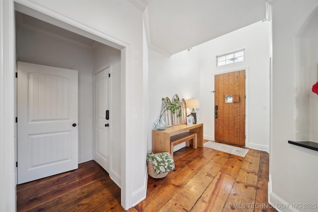 foyer entrance featuring dark wood-type flooring and ornamental molding