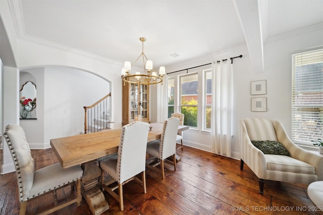 dining room with ornamental molding, an inviting chandelier, and dark hardwood / wood-style flooring