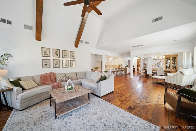 living room featuring dark wood-type flooring, ceiling fan with notable chandelier, and high vaulted ceiling