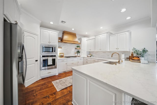 kitchen with premium range hood, stainless steel appliances, sink, and white cabinets