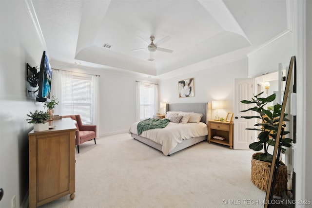 bedroom featuring crown molding, light colored carpet, ceiling fan, and a tray ceiling