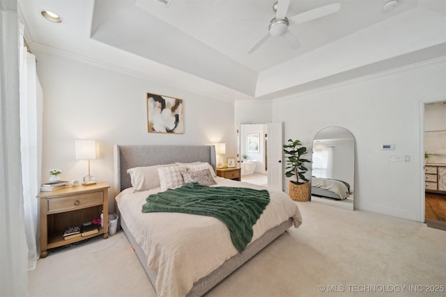 bedroom with ornamental molding, light colored carpet, ceiling fan, and a tray ceiling