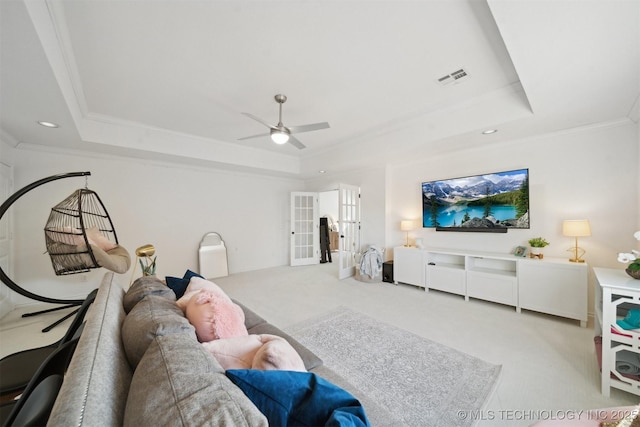 living room with french doors, crown molding, and a tray ceiling