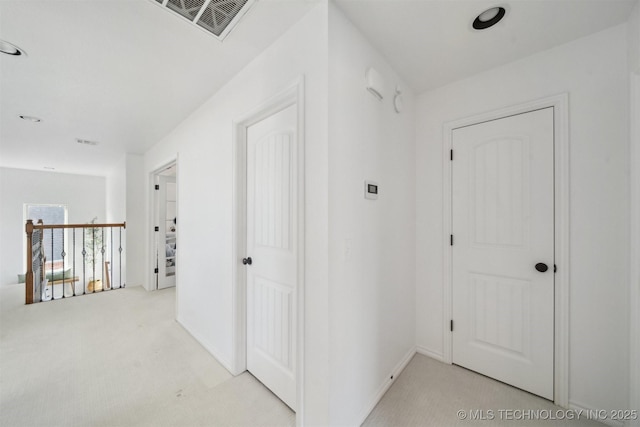 corridor featuring light colored carpet