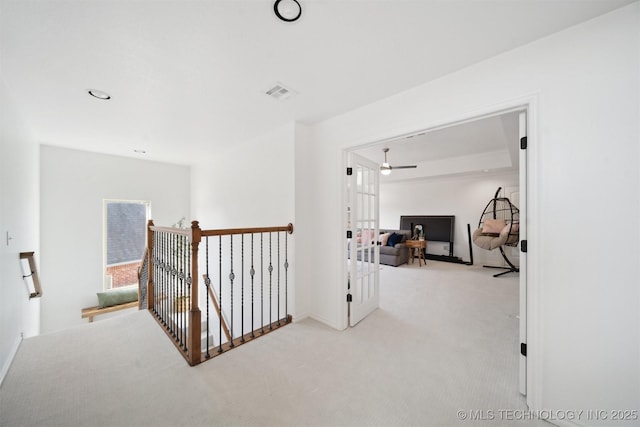 hall featuring light carpet and french doors