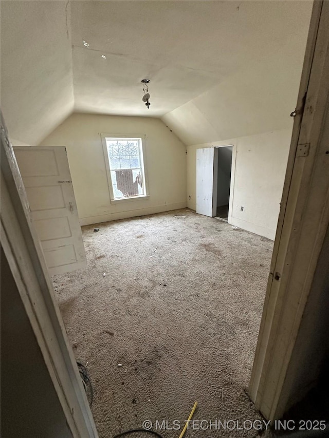 additional living space featuring lofted ceiling and light carpet