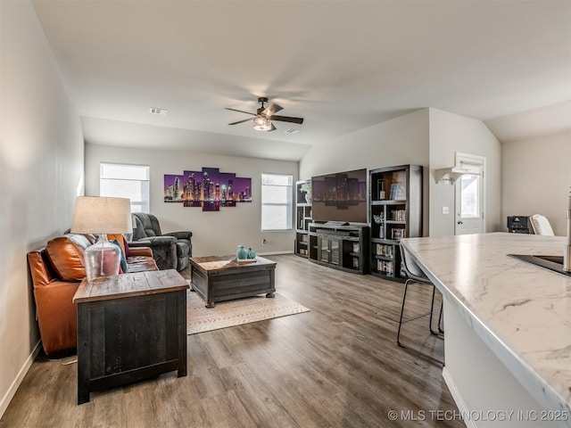 living room with lofted ceiling, hardwood / wood-style flooring, and ceiling fan