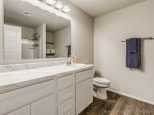 bathroom featuring wood-type flooring, toilet, vanity, and a shower