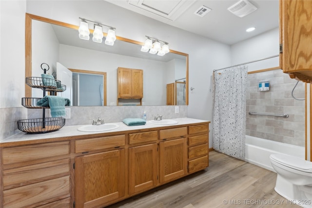 full bathroom featuring tasteful backsplash, hardwood / wood-style flooring, vanity, toilet, and shower / bathtub combination with curtain