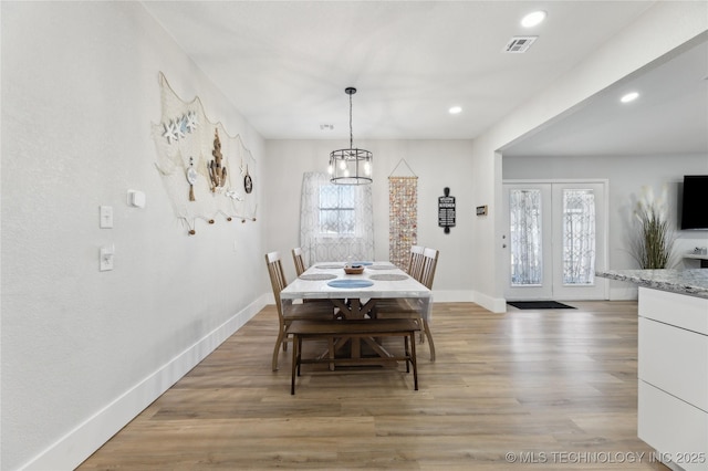 dining area with plenty of natural light, a notable chandelier, and light hardwood / wood-style floors