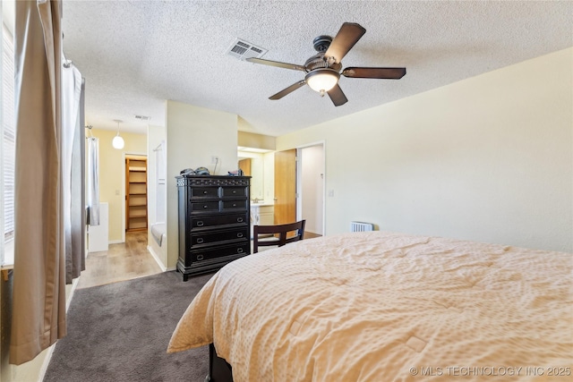 bedroom featuring ceiling fan, carpet floors, and a textured ceiling