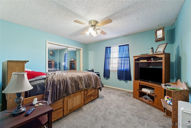 carpeted bedroom with ceiling fan, a closet, and a textured ceiling