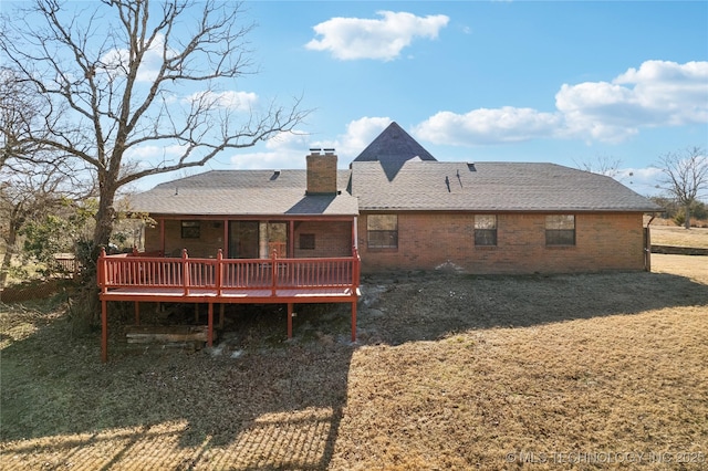 back of property with a wooden deck and a yard