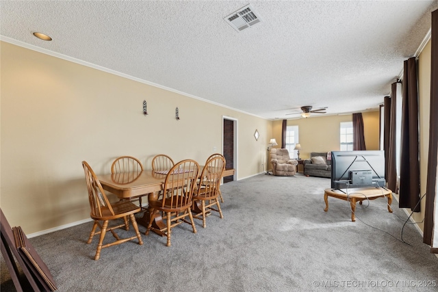 dining space with crown molding, carpet flooring, and a textured ceiling