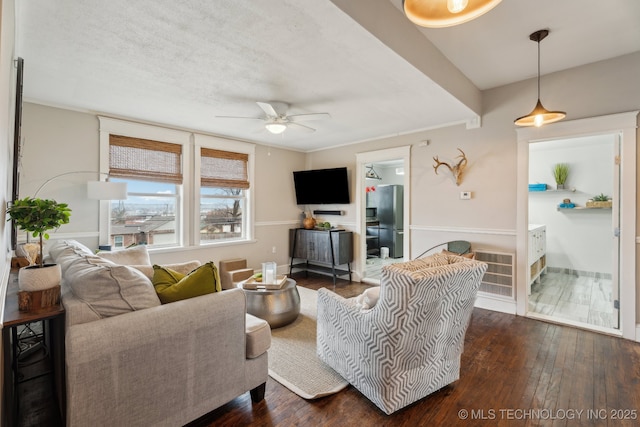 living room with ceiling fan, a textured ceiling, and dark hardwood / wood-style flooring