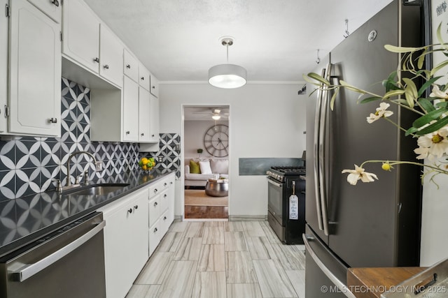 kitchen with appliances with stainless steel finishes, white cabinetry, sink, backsplash, and ornamental molding