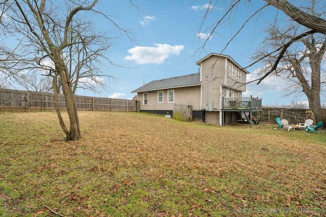 rear view of property with a wooden deck and a yard