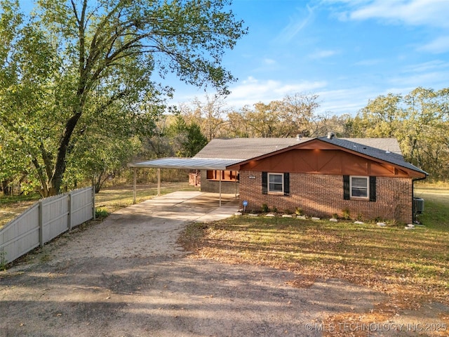 view of front of property featuring central AC, a front yard, and a carport