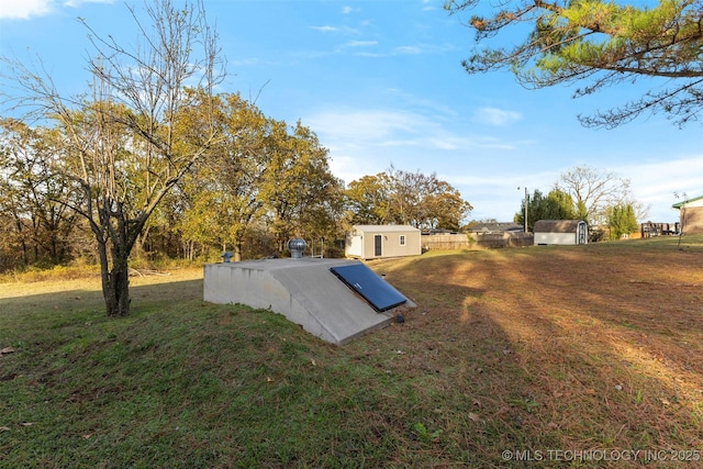 view of storm shelter with a storage shed and a yard