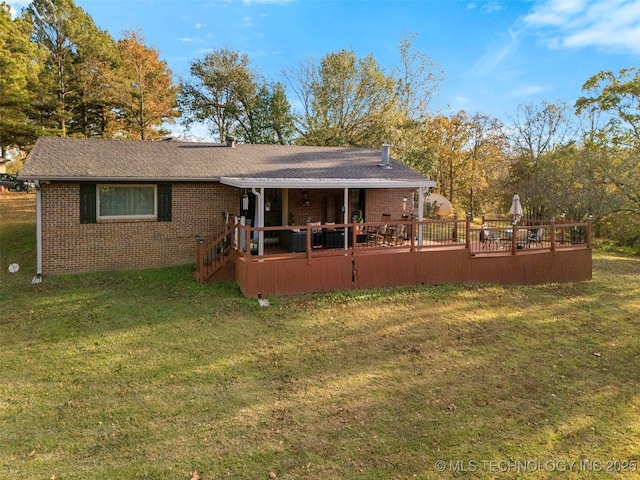 back of property featuring a wooden deck and a yard