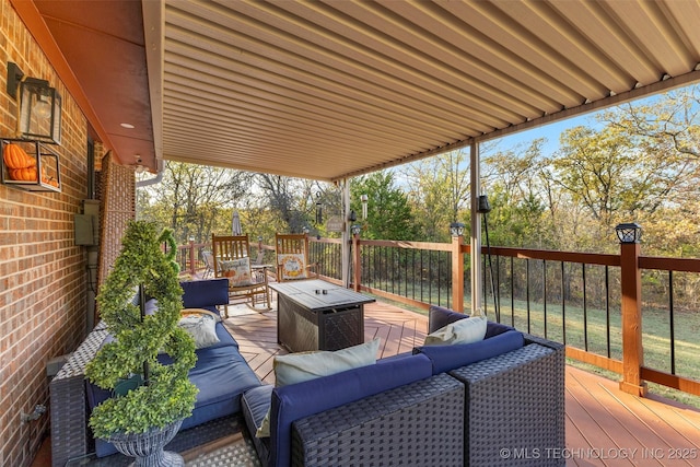 wooden deck with an outdoor living space with a fire pit