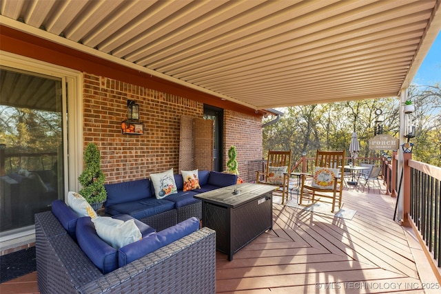 wooden terrace with an outdoor living space with a fire pit