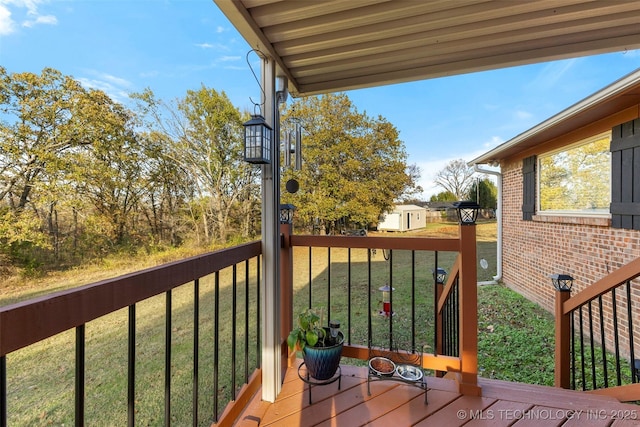 deck with a storage shed and a yard