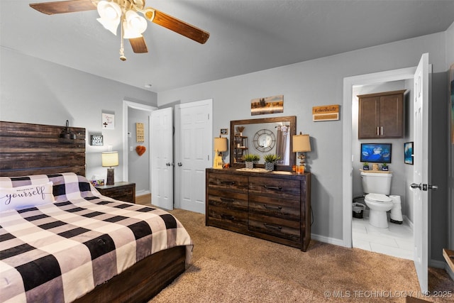 bedroom with ceiling fan, light colored carpet, and ensuite bathroom