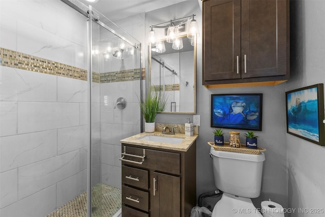 bathroom with vanity, a shower with shower door, and toilet