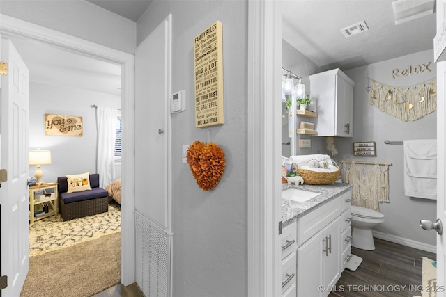 bathroom featuring vanity, wood-type flooring, and toilet