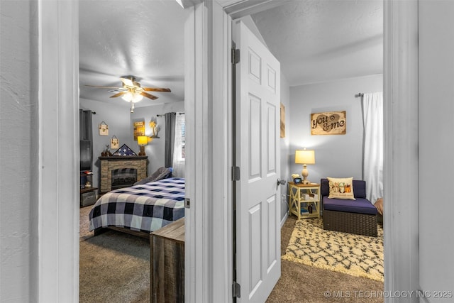 carpeted bedroom with ceiling fan and a textured ceiling