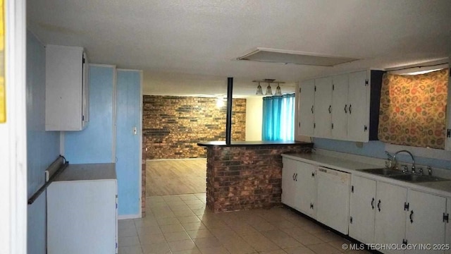 kitchen with sink, white cabinetry, brick wall, white dishwasher, and light tile patterned flooring