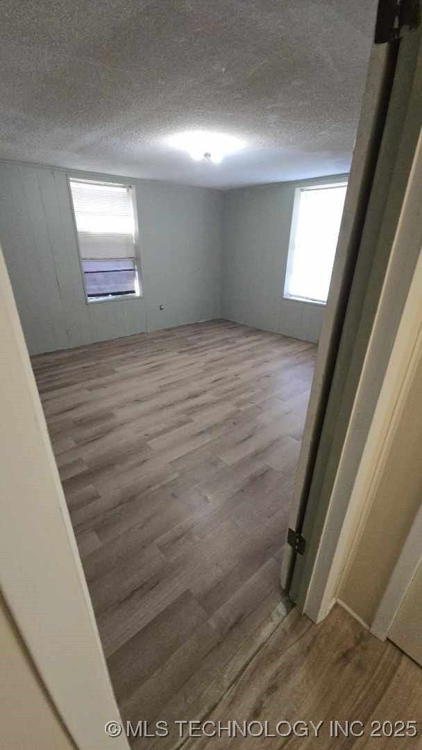 empty room featuring hardwood / wood-style flooring and a textured ceiling