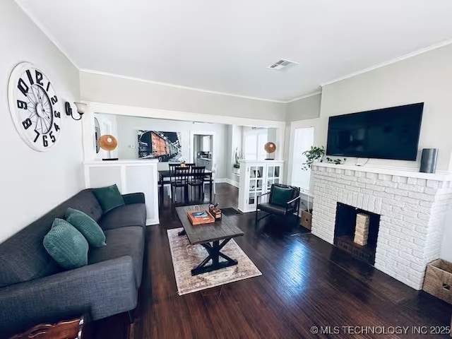 living room featuring ornamental molding, dark hardwood / wood-style floors, and a fireplace