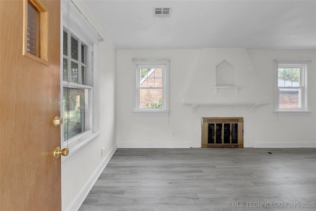 unfurnished living room featuring a fireplace and light wood-type flooring